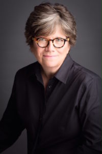 Photo of Joan Garry; author is wearing glasses, smiling